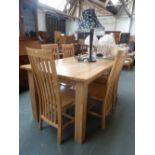 A modern oak kitchen table with six slat back chairs