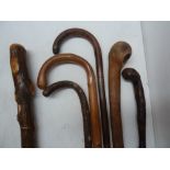 A selection of six wooden walking sticks and canes