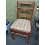 An oak dining chair with striped upholstered seat