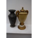 A gold painted lamp base with side handles together with a black stoneware pot with incised