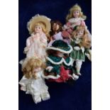 A collection of china dolls including two with pink lace dresses,