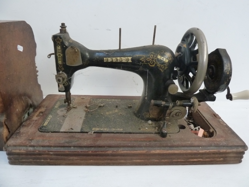 A vintage sewing machine in mahogany and banded case