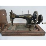 A vintage sewing machine in mahogany and banded case