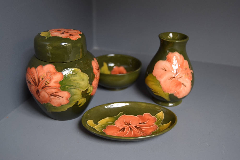 Four pieces of Moorcroft pottery in the hibiscus pattern, green glazed,