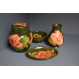 Four pieces of Moorcroft pottery in the hibiscus pattern, green glazed,