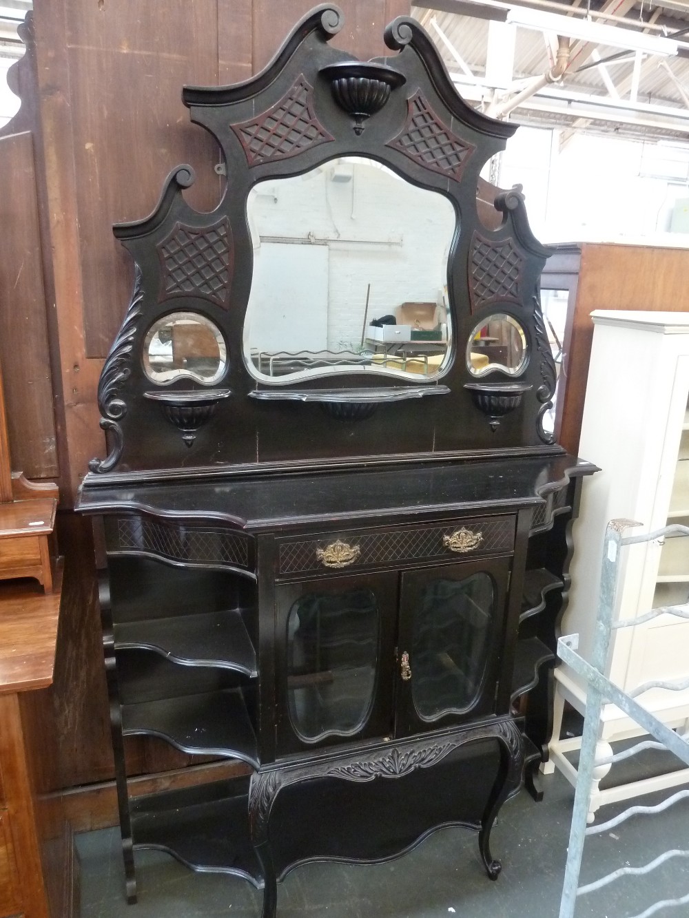 A continental ebonised dressing table broken pediment over three mirrors with central drawer and