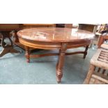 An oval coffee table with fluted square legs with X stretcher