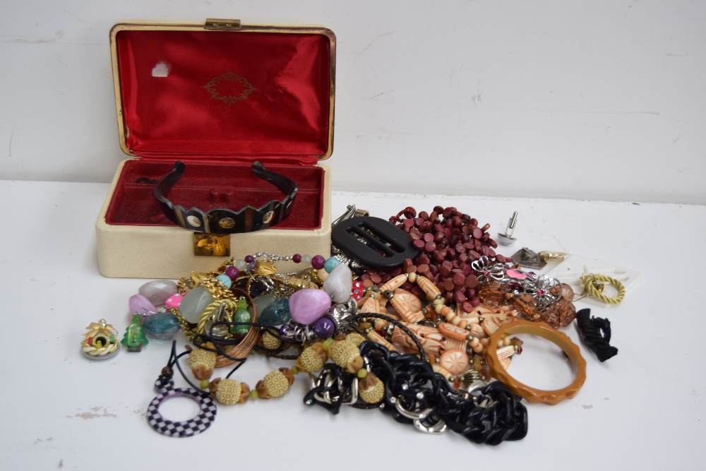 A collection of various pieces of costume jewellery with a cream jewellery box