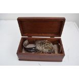 A wooden box of jewellery to include white metal rings, bracelets, necklaces,