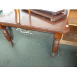 A late 19th/early 20th century mahogany extending dining table with reeded turned legs,