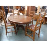 A Victorian oval oak pedestal table on turned supports and scrolling legs on castors