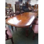 A Victorian style mahogany extending 'D' end dining table raised on fluted legs and castors