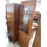 A corner display cabinet with glazed doors over cupboard