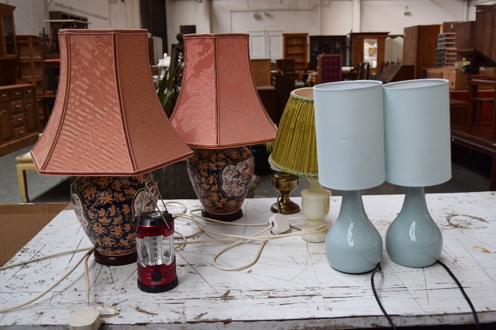 A qauntity of various lamps including two oriental style lamps with peach shades, an onyx lamp,