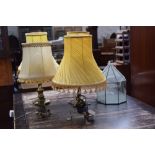 Four brass based table lamps with yellow shades and a stained glass lantern by Chris Franken