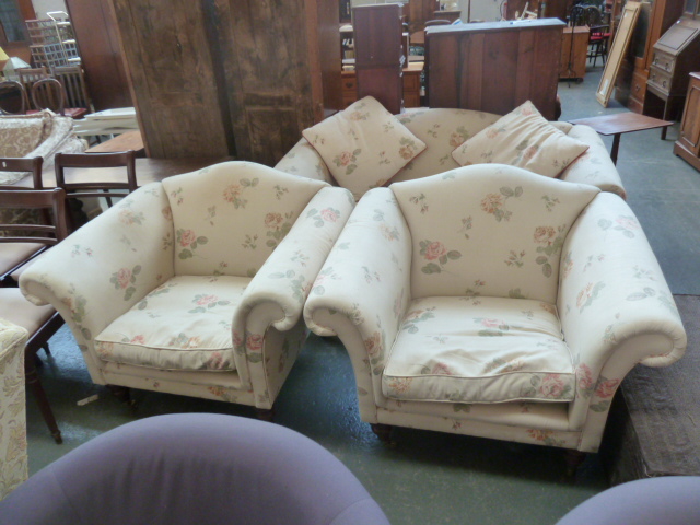 A Laura Ashley three piece suite including a two seater sofa and two armchairs each with shield