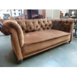 A two seater button back chesterfield sofa upholstered in brown fabric