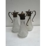 Three cut glass Claret jugs with silver plated tops