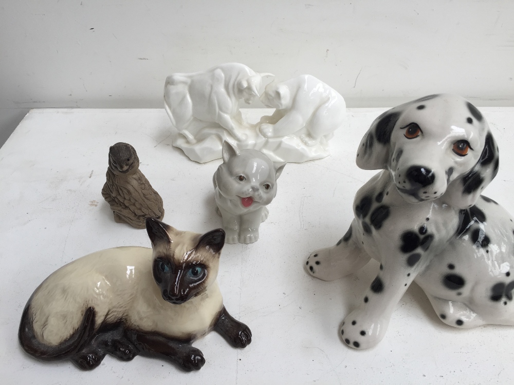 Five ceramic figurines including: a Royal Doulton Siamese cat model 1559,