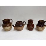 Three pieces of Royal Doulton Lambeth pottery including two water jugs and a teapot with typical