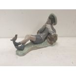A Lladro figurine of a lying down boy with bird on foot 15cm height