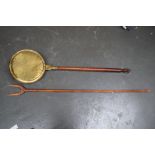 A vintage wooden hay fork and a bed pan