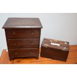 A small stained pine chest of drawers with three drawers together with a vintage box of wax candles