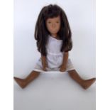 A Sasha Morgenthaler doll with long brown hair and fringe in a white dress with knickers