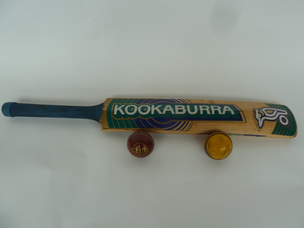 A Kookaburra cricket bat with a Readers Club leather cricket ball and one other