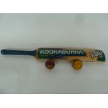 A Kookaburra cricket bat with a Readers Club leather cricket ball and one other