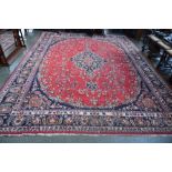 A large Persian rug with navy and maroon fields and floral borders