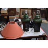 A pair of green glazed ginger jar style table lamps with orange shades