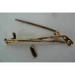 A 9ct gold tie pin depicting two crossed golf clubs and ball, length 5cm,
