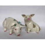 Two decorative ceramic pigs of floral design, one seated and marked M.