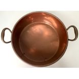 A copper preserve pan with rolled rim and opposing,