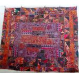 A large antique Afghan wall hanging consisting of numerous small pieces of fabric stitched to a