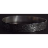 A silver bangle with an engraved scene depicting animals all around, 7 cmD 0.