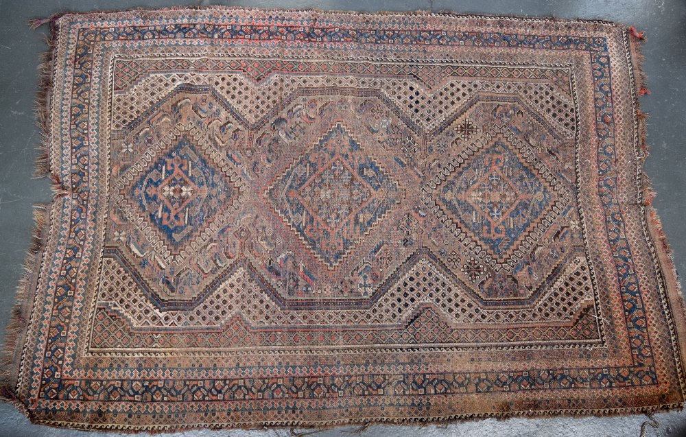 A Caucasian rug with red fields and three central lozenges and geometric borders 170 x 250cm