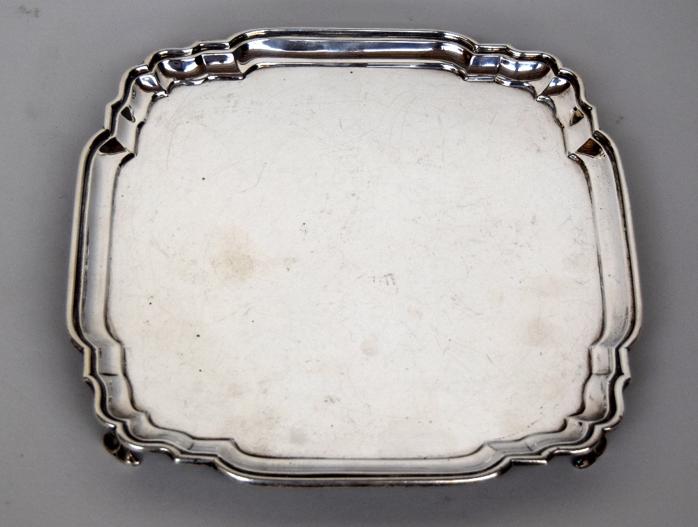 A George V silver salver raised on four feet by C.S. Harris & Sons Ltd London, 1932, 26.5cmW, 19.