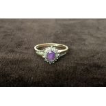 A 9ct gold ring with an amethyst surrounded by diamond chips