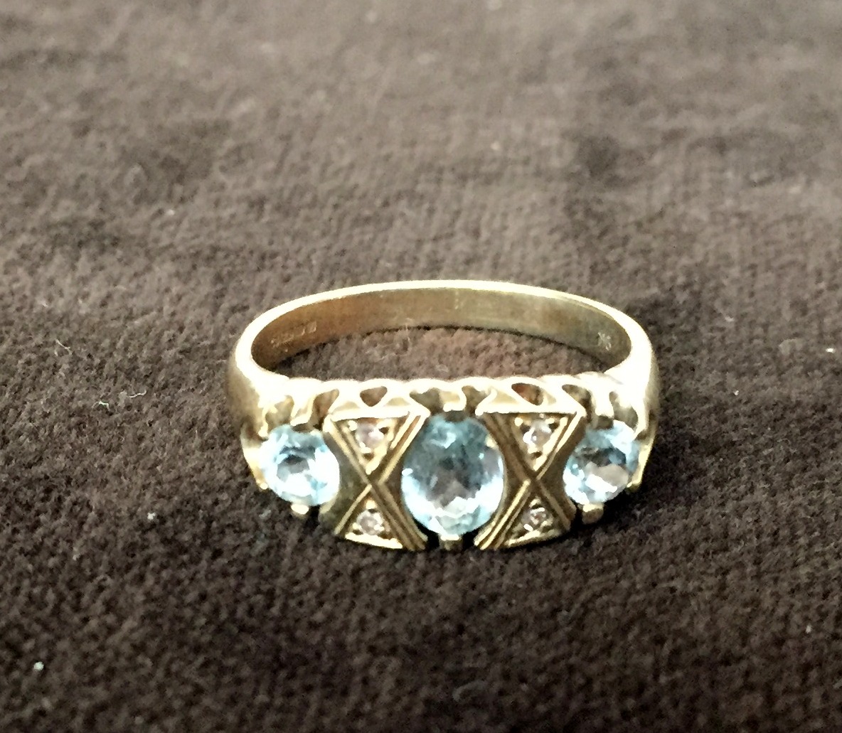 A 9ct gold ring with three pale blue stones