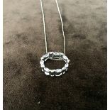 A silver square link chain with silver ring pendant with seven white stones together with a spare