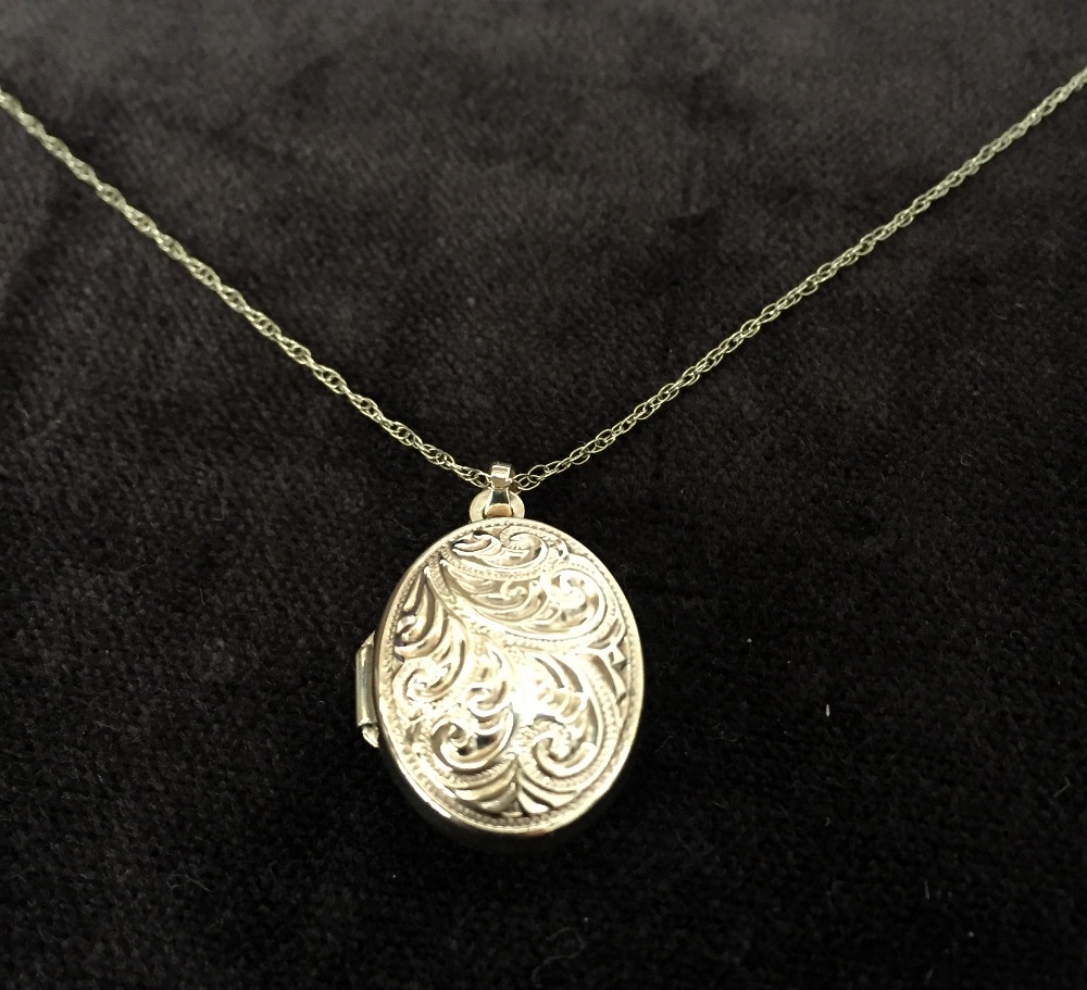 A 9ct small chain necklace with an oval shape locket