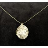 A 9ct small chain necklace with an oval shape locket