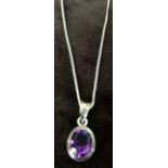 A sterling silver chain with a purple stone oval shaped pendant