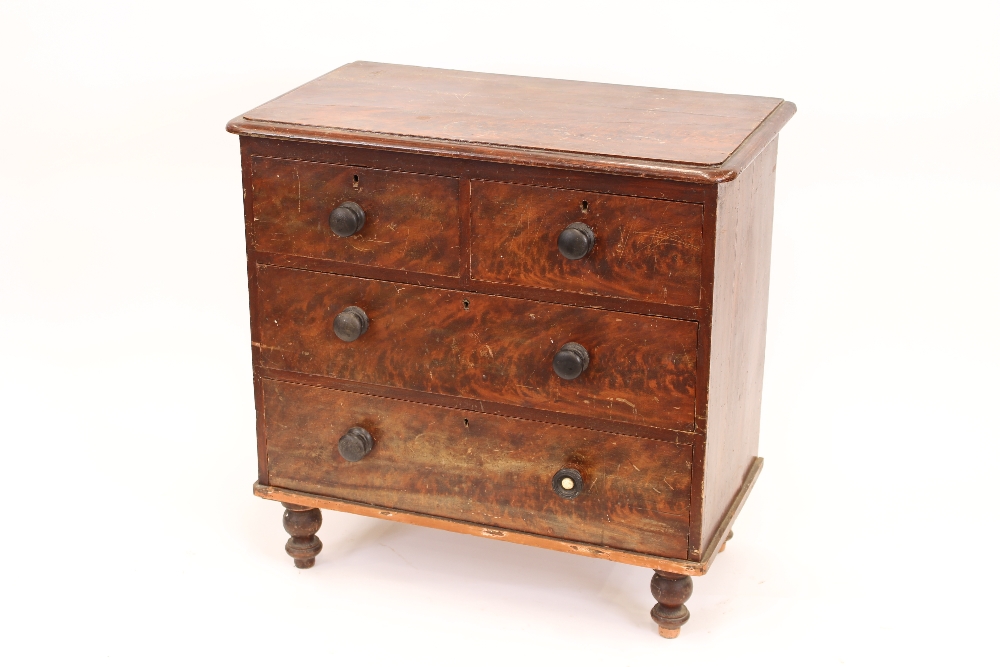 A Victorian grained pine chest of drawers, rectangular top with rounded corners and a moulded edge,