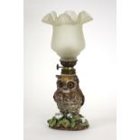 A Victorian porcelain nursery lamp, designed as an owl, encrusted with flowers,