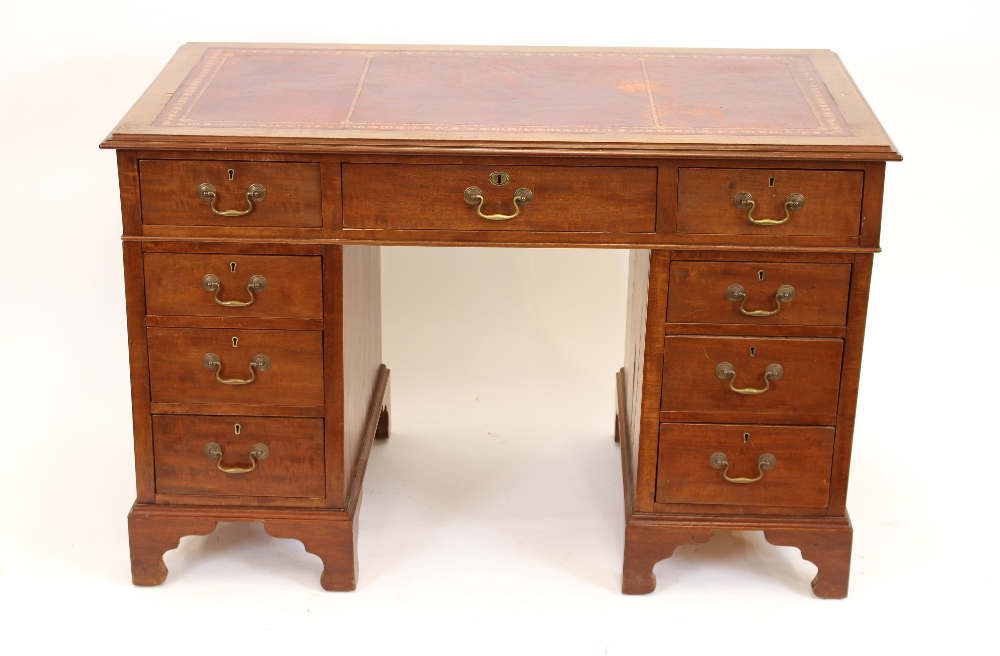An Edwardian mahogany twin pedestal desk, rectangular top with a tooled leather inset,