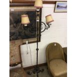 A wrought iron three branch standard lamp