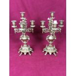 A pair of ornate brass five branch candelabra